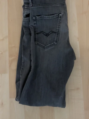 Gråa Replay jeans thad modellen - Säljer ett par gråa jeans i slim fit/regular från Replay. Byxorna har en trasig lapp men de är inget man lägger märke till och de är enkelt o dölja genom bälte. Storlek 158cm. Skriv gärna om ni har några frågor och pris kan alltid diskuteras