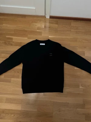 Svart crewneck från Samsøe Samsøe - Snygg äkta svart crewneck från Samsøe Samsøe i stilren design. Tröjan har rund halsringning och diskret logga på bröstet. Säljer på grund av att den är för stor för mig.