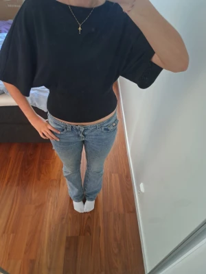 Svart croppad topp med vida ärmar - Säljer en svart croppad topp med vida, korta ärmar och båthalsringning. Toppen har en loose passform upptill och sitter tightare i midjan. Perfekt att styla med jeans eller kjol för en trendig look.🥰