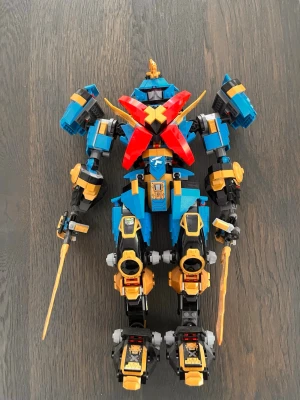 Lego-robot samuraj med svärd - Säljer en färgglad Lego-robot i samurajstil med blå, röda, gula och svarta delar. Roboten har två svärd, stora axelskydd och detaljerade ben och armar. Perfekt för dig som gillar att bygga och leka med robotar eller samurajer.