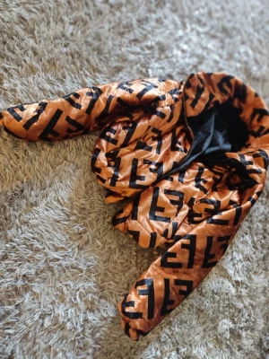 Orange pufferjacka från Fendi - Säljer en riktigt snygg orange pufferjacka från Fendi med stora svarta loggor över hela jackan. Jackan har dragkedja framtill och är quiltad för extra värme. Perfekt statement-plagg för dig som vill sticka ut i mängden.
