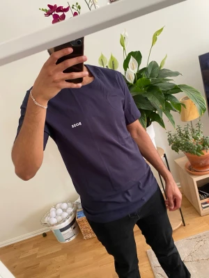 Mörkblå BOSS t-shirt i bomull - Snygg mörkblå t-shirt från BOSS med diskret logga på bröstet. Klassisk rund hals och korta ärmar. Tillverkad i mjuk bomull för skön känsla och enkel passform. Perfekt till jeans eller shorts för en clean look.