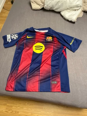 FC Barcelona 24/25 Lamine Yamal #10 Hemmatröja Nike M  - Helt ny FC Barcelona hemmatröja 2024/25 med Lamine Yamal #10 på ryggen.  ✅ Storlek M ✅ Aldrig använd ✅ Nike Dri-FIT ✅ Champions League-patch på ärmen ✅ Snyggt tryck med Lamine Yamal #10 ✅ Inga defekter eller skador  Perfekt för Barça-fans, samlare eller dig som vill representera en av världens största talanger. Tröjan är i toppskick och redo att användas direkt.  📦 Snabb frakt 💬 Skriv vid frågor eller om du vill ha fler bilder