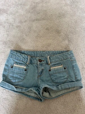 Lågmidjade shorts från Only - Supersnygga Lågmidjade jeansshorts från Only med fina detaljer och snygga fickor. Säljs för att de är för små för mig. Super bra skick och inga defekter. Midjemåttet är 82cm💞bara skriva om du vill ha fler bilder