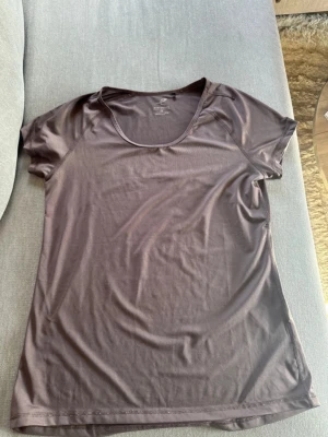 Syrenlila tränings-tshirt från Energetics - Snygg brun tränings-tshirt från Energetics med DRYPLUS eco-material som andas. T-shirten har rund halsringning och korta ärmar, perfekt för gymmet eller löprundan. Materialet är lätt och snabbtorkande för maximal komfort under träning.