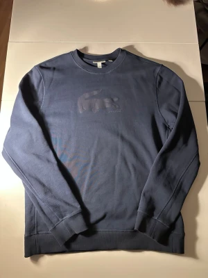 Mörkblå Lacoste sweater - Tja den är i mycket bra skick i storlek Xl/L från Lacoste