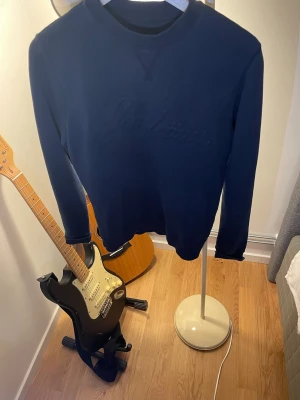 Mörkblå sweatshirt från Stenströms - Mörkblå sweatshirt från Stenströms med broderad logga på bröstet. Tröjan har rund halsringning, ribbade muddar vid ärmslut och nederkant samt en klassisk relaxed fit. Perfekt för dig som gillar stilrena och tidlösa plagg.