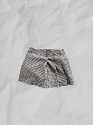 Miniskirt från Gina Tricot - Rutig kort kjol från Gina Tricot i brunt och svart. 🤎Kjolen har ett klassiskt veck framtill och har endast använts en gång.