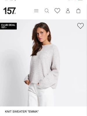 Ljusgrå stickad tröja  - Mysig ljusgrå stickad tröja från 157, modell Emma. Tröjan har en avslappnad passform, rund halsringning och långa ärmar. Tillverkad i ett mjukt material som ger en fluffig känsla. Perfekt för lager på lager och enkel att matcha.