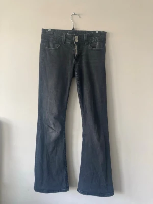 Svarta bootcut jeans 🖤 - Säljer mina bootcut Gina jeans i svart/grå färg och de har dubbel knapp i midjan. De är i storlek 152 🥰