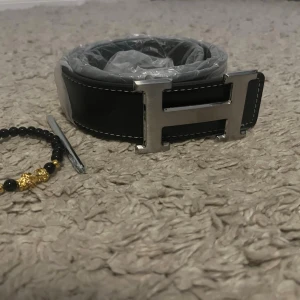Svart H bälte  - Säljer mitt herrmes bälte 115cm helt nytt. Armband ingår. Hör av er vid frågor och funderingar.armbandet ingår ej!