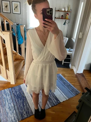 Vit omlottklänning med volanger - Säljer nu min fina avslutningsklänning från 9:an. Klänningen är från bubbleroom i storlek 34. Passar perfekt till student eller som skolavslutningsklänning men också som en sommarklänning. Den är vit och i luftigt material, endast använd 1 gång (inga deffekter) Orginal pris: 800kr💗 