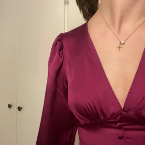 långklänning - säljer denna vackra klänning då den tyvärr är för tight runt höfterna, vilket kan vara bra att tänka på. den är i ett silkesliknande tyg med fina knappar där fram. klänningen är endast provad! köptes för runt 800 kr💗den är midi även på mig som är 179❣️