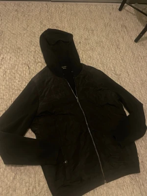 Massimo dutti cardigan - Snygg svart hoodiejacka med dragkedja framtill och fickor på sidorna. Jackan har en quiltad framsida och mjuka ärmar samt huva. Perfekt för lager på lager och streetwear-stil.