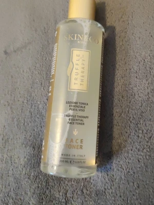 Skin&Co Truffle Therapy Face Toner - Skin&Co Truffle Therapy Face Toner är en ansiktstoner i en genomskinlig plastflaska med guldfärgat lock. Tonern innehåller naturliga extrakt av tryffel, ringblomma, ros och rosmarin och är framtagen för att rengöra och fräscha upp huden.