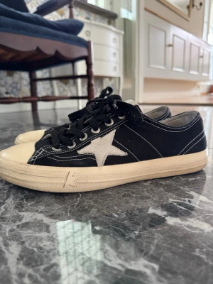 Golden Goose V Star - Svarta Golden Gooose VStar🪄. Dessa skor är hyfsat sällsynta på secondhand marknaden och ny priset är 5999kr✨ Det passar bra med nästan allt och kan blandas med många olika stilar. Det är i bra skick, det ända defekterna är nog den gråa mockan som är lite smutsig men är definitivt något som går att fixa och ena sulan vid hälen som man ser på en av bilderna, pris kan diskuteras vid snabb affär. Hör av er vid frågor!