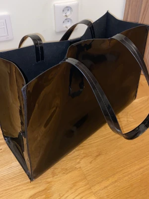 Svart lack väska - Rymlig. Svart insida. Silver knapp. Från HM.