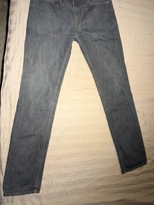 Acne Studios jeans - Säljer ett par grå jeans från Acne Studios med rak passform och klassisk femficksdesign. Jeansen är tillverkade i denim och har snygga kontrastsömmar. Perfekta för en slim och trendig look. Midjan 31 och ben 32. Mycket bra skick.