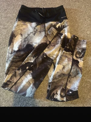 Mönstrade leggings från Swedemount - Snygga leggings från Swedemount med högt svart midjeband och dragsko. Mönstret är i svart, grått, beige och vitt med en cool marmoreffekt. Perfekta för träning eller chill. Materialet är stretchigt och följsamt.