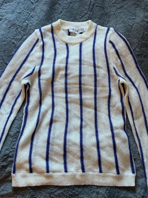 Vit stickad tröja med blå ränder NA-KD - Snygg vit stickad tröja från NA-KD med vertikala blå ränder..