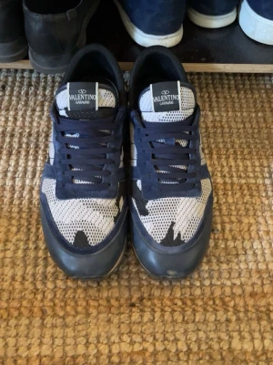 Valentino Garavani sneakers blå/vit - Snygga sneakers från Valentino Garavani i blått och vitt med coolt kamouflagemönster. Skorna har snörning och ovandel i mesh och syntet för en sportig vibe. Köpt förra vintern på en app som heter vestaire (en second hand app för exclusiva märken) men har inte använt då mycket då jag tycker om ett annat par av mina skor mer, skriv för frågor, pris är diskuterbart som alltid, glad påsk allihopa 🐣❤️