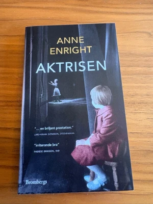 Aktrisen av Anne Enright - Romanen 'Aktrisen' av Anne Enright handlar om den irländska skådespelerskan Katherine O'Dell och hennes dotter Norah. Boken är i pocketformat med ett omslag i mörka färger och motiv av en kvinna i röd kappa. Perfekt för dig som gillar gripande och psykologiska berättelser.