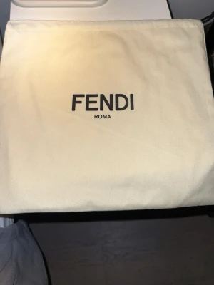 Vit fendi keps - Stilren vit bucket hat från Fendi med klassisk logga broderad framtill. Hatten är tillverkad i ett mjukt tygmaterial och har en rund form med bred skärm. Perfekt accessoar för att lyfta din outfit med en exklusiv touch.