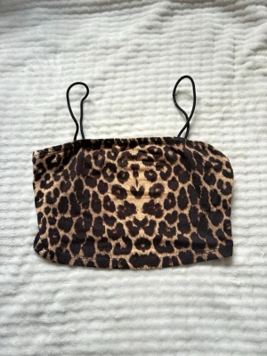Leopardmönstrat linne - Snygg bandeau topp med leopardmönster och tunna axelband. Toppen har en croppad passform och är perfekt för dig som vill sticka ut. Materialet känns mjukt och stretchigt, vilket gör den bekväm att bära hela dagen!💓🌸