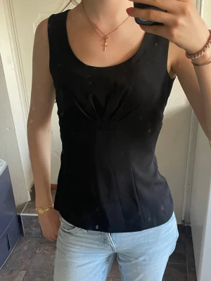 Svart topp  - Snygg svart ärmlös topp med figurnära passform. Perfekt som fest topp eller till sommaren. Köpt på vinted men säljer vidare💗