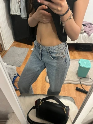 Ljusblå raka jeans med hög midja - Säljer ett par ljusblå jeans med raka ben och hög midja. Jeansen har klassisk femficksdesign och är tillverkade i denim. Perfekta för en avslappnad och trendig look.