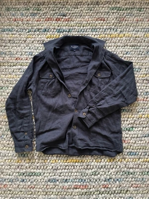 Mörkblå Overshirt Bondelid - Snygg mörkblå overshirt från Bondelid. Skjortan har två bröstfickor med knappar, klassisk krage och långa ärmar med knapp vid manschetten. Perfekt för en avslappnad men stilren look.