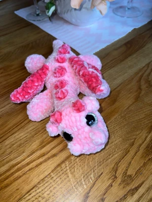 Rosa virkad drake - Denna urgulliga drake längtar efter sitt för alltid hem🩷🌸 Det är en ljusrosa drake med mörkrosa detaljer, virkat med mjukt garn från Rusta som heter Klara🩷🌸 Den har hårda silvriga ögon som inte går att ta av, sitter som bergen✨ Den är cirka 30 cm lång🌸