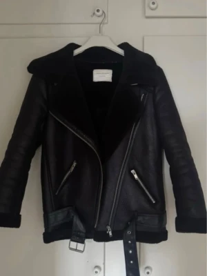 Svart skinnjacka med bälte Zara  - Postar samma dag om du köper innan 13.00 🎀🎀 Snygg svart skinnjacka från Zara med bred krage, dragkedjor och bälte i midjan. Jackan har två snedställda fickor med dragkedja och detaljer i silver. Perfekt för dig som vill ha en cool och trendig look. kolla in mina andra annonser