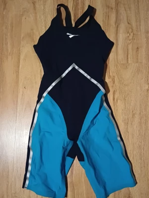 Svart och blå tävlingsbaddräkt  - Säljer en sportig tävlingsbaddräkt från finisi svart och blått med silvriga detaljer. Har inte används många gånger alls