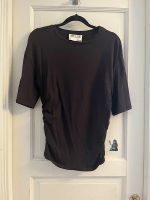 Mörkbrun sommar topp som sitter år i midjan - Mörkbrun tröja med lite längre armar. Indragen i midjan för en snygg look. Använt fåtal gånger. Köpt på Vero Moda