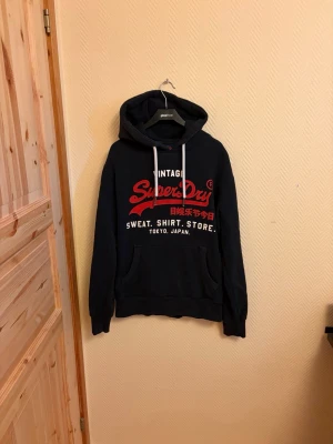 Vintage Superdry Hoodie  -  En väldigt snygg vintage Superdry Hoodie i väldigt bra skick. Skulle säga 8/10 🙌 Storlek M men passar även storlek L | 🤩                                                 Skriv vid mera frågor/bilder 💬