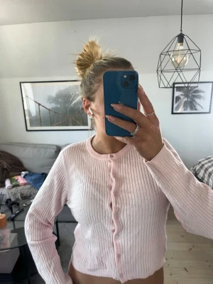 Ljusrosa ribbad kofta från Gina Tricot - Söt ljusrosa kofta från Gina Tricot med ribbat tyg och rund halsringning. Skavanker som man kan se på bild 4!