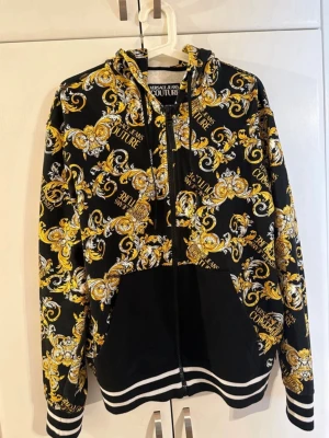 Versace Jeans Couture mönstrad hoodie - Knappt använd hoodie med dragkedja från Versace Jeans Couture, nypris var 4545kr 