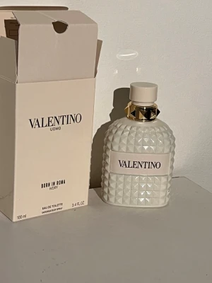 Valentino Uomo Born In Roma Ivory EdT - Exklusiv parfym från Valentino, Uomo Born In Roma Ivory, Eau de Toilette. Flaskan är vit med ett coolt nitat mönster och gulddetaljer vid halsen. Kommer i en stilren, ljus förpackning. Volymen är 100 ml.