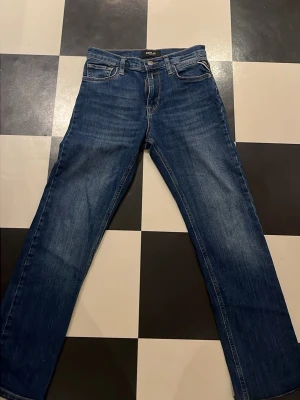 Blå jeans från Replay - Klassiska blå jeans från Replay. Jeansen har en snygg tvättad look och detaljer som läderpatch bak i midjan. Perfekta till en avslappnad stil och passar till det mesta i garderoben.