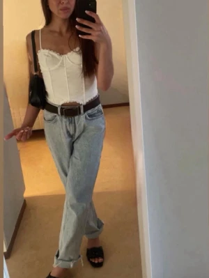 Ljusblå raka jeans från Zara - Säljer ett par ljusblå raka jeans från Zara med hög midja och klassisk femficksdesign. Jeansen har en avslappnad passform och råa kanter vid bensluten för en trendig look. Perfekta till sneakers eller sandaler för en chill stil.