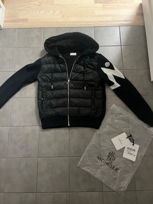 Moncler jacka  - Säljer en sprillans ny jacka då jag bara har testat den, anledningen för jag säljer den är för att det var fel storlek. Som sagt är jackan i nytt skick med etikett och påse då det medföljer skicket på jackan är 10/10 och är perfekt för våren som är runt hörnet då denna jacka ska bäras. Storleken på denna jackan är liten som Moncler i sig har små storlekar skulle säga att den sitter som xs och en liten s för att den ska kunna sitta bra. Skriv för funderingar. Scan innanför jackan och på loggan 