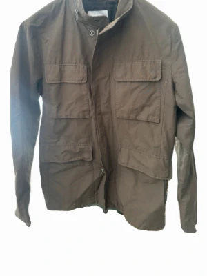 Brun jacka från Selected Homme - Snygg mörkgrön jacka från Selected Homme med fyra stora fickor framtill. Inga defekter och i storlek L(true to size)!