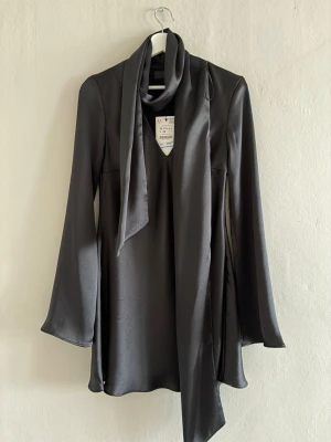 Klänning från ZARA - Elegant klänning i siden material med volanger 