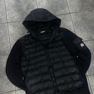 Svart pufferjacka från Moncler - Säljer en svart cardigan från Moncler med huva och dragkedja framtill. Cardiganen har det klassiska Moncler-märket på ärmen och quiltad design. Använd i princip 4 gånger och är helt felfri. Perfekt till dig som vill ha en fräschare stil till våren och sommaren men även nu under vintern. Priset är diskuterbart🌟🌼💝💝🌼🐝