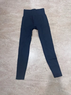 H&M träningstights  - Ett par mörkgrå H&M Move träningstights i stl xs säljs för 150 kr. 