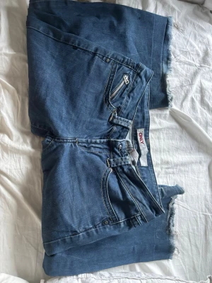 Blå raka jeans från ONLY - Säljer ett par blå väldigt lågmidjade jeans från ONLY  passar mig bra i midja och långd, är 170 och bär ofta Xs 