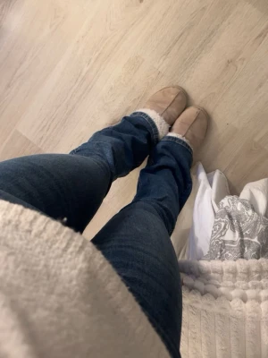 Blå bootcut jeans med medelhög midja - Säljer ett par klassiska blå bootcut jeans med mid waist och fickor. Jeansen har en snygg tvätt. Perfekta till sneakers eller boots och passar till alla tillfällen. Materialet är mjukt och stretchigt denim.