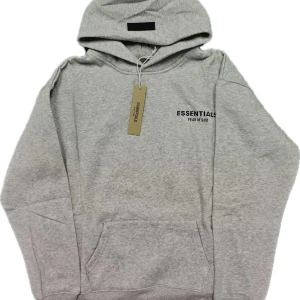 Essentials hoodie  - Brand new Essentials Fear of God hoodie in light grey, still in packaging. Condition: 10/10 Size: L • Color: Light Grey Fast and careful shipping