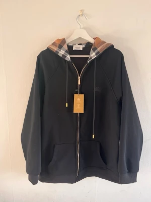 Svart burberry Hoodie - Säljer en stilren hoodie från burberry. Den är storlek L-XL. Oanvänd